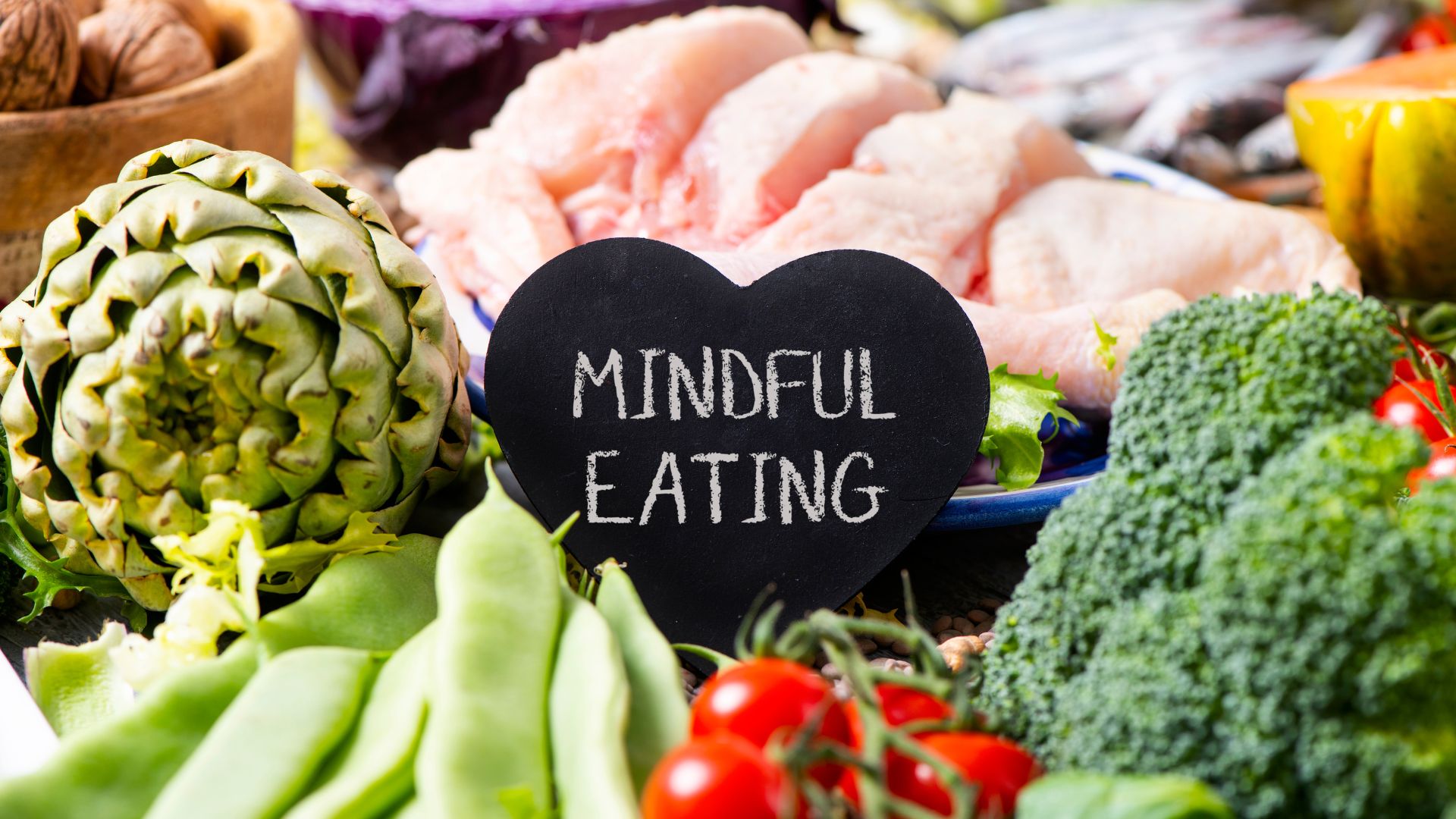 An array of healthy foods and a chalkboard that reads, "mindful eating."